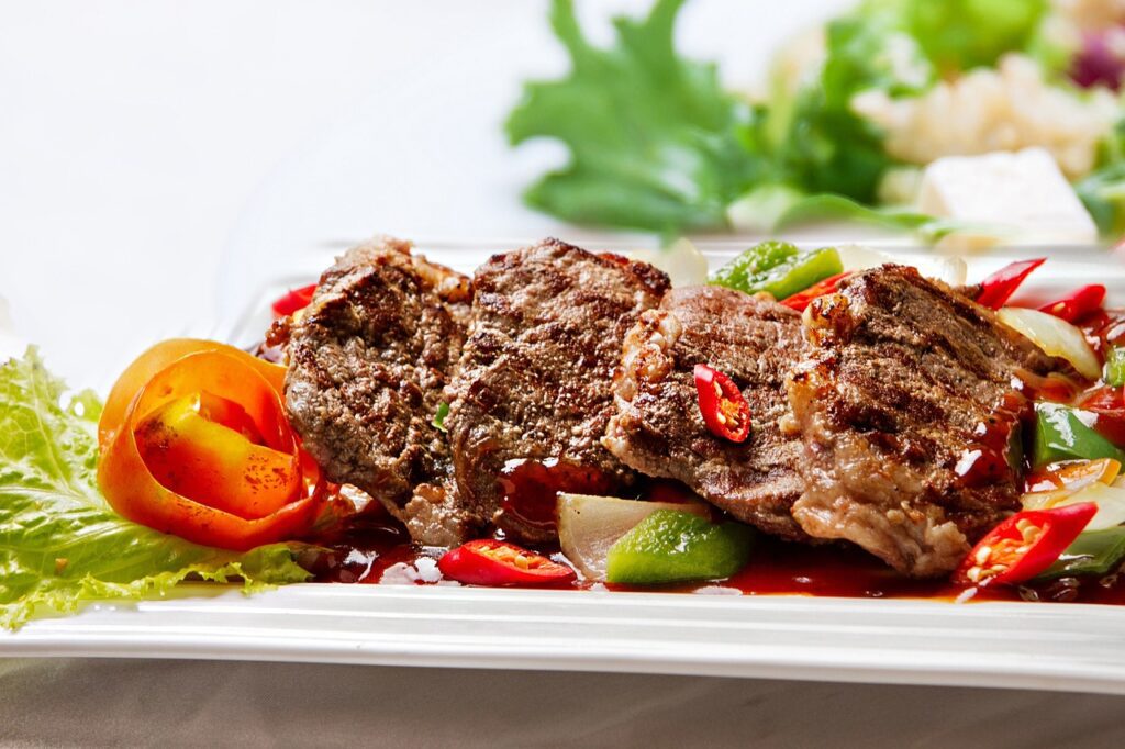 beef steaks garnished with tomatoes, lettuce.