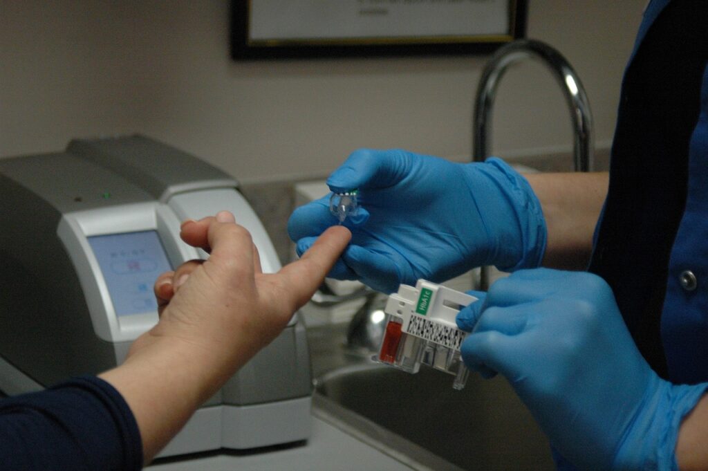 diabetic patients, nurse giving a finger-stick to a diabetic patient.